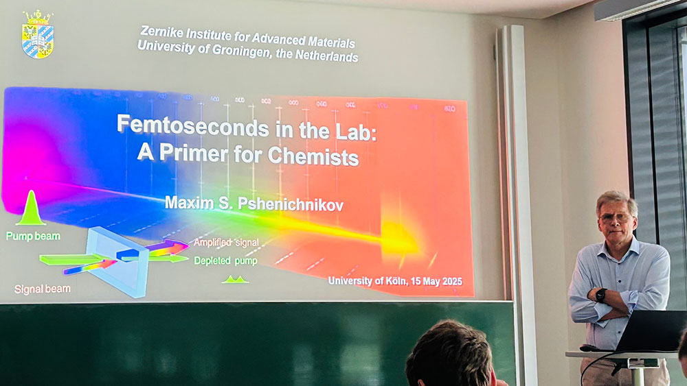 Prof. Pshenichnikov gives a scientific talk to a group of PhD students in a university lecture room.
